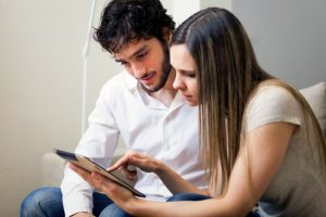 Small Loans Banner - Couple with bad credit looking at loan options on their tablet