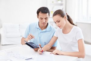 Small Loans Banner - Young couple working out their finances before applying for a loan